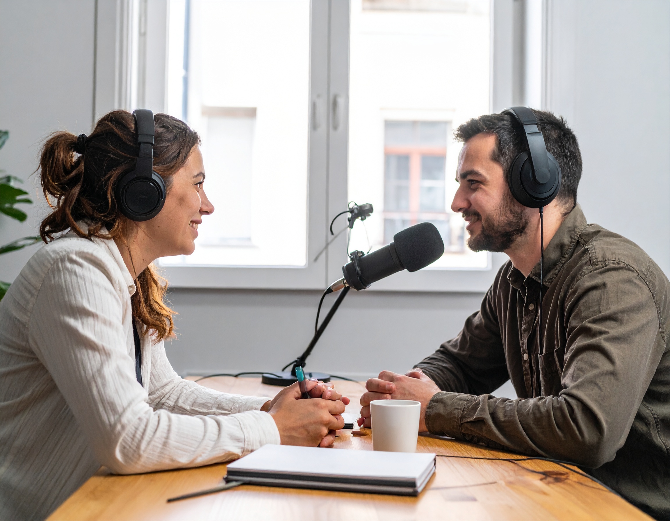 Ein Mann und eine Frau podcasten im Studio.